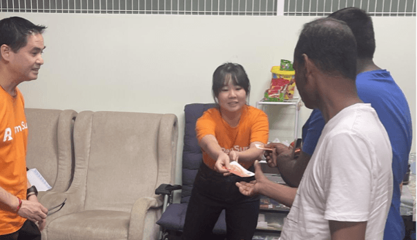 EFGH team member Teh Yun Ying conducting remittance user research with migrant workers in a Singapore dormitory.