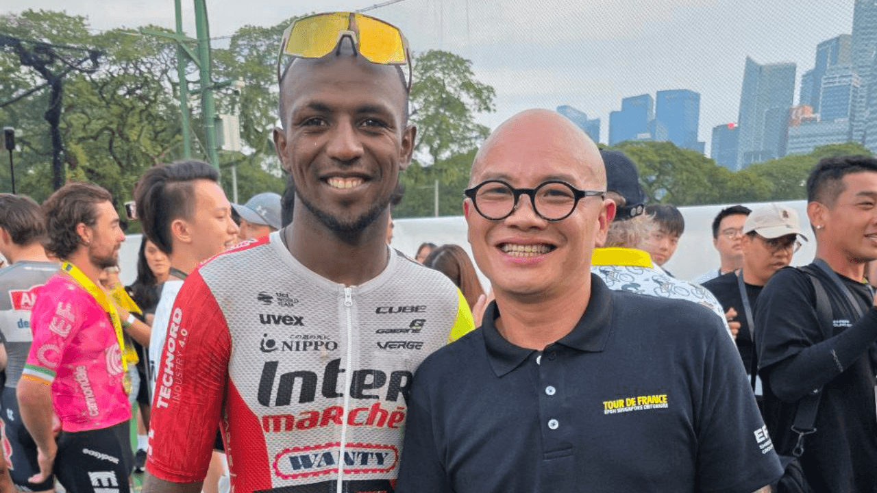 Biniam Girmay (left) and EFGH Executive Chairman Dennis Ng (right) smiling together at the Tour de France EFGH Singapore Criterium.